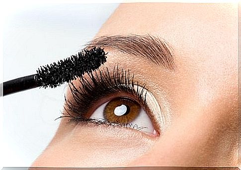 Woman putting on mascara