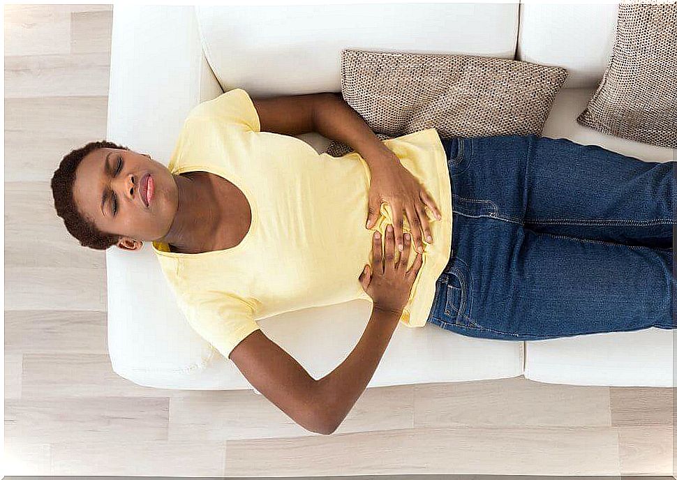 A woman lying down with a stomach ache.