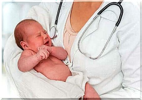 A baby in the arms of a pediatrician. 