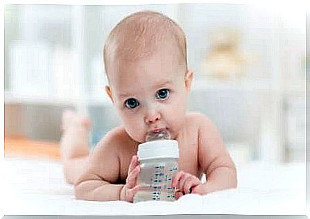 A baby who drinks water from a bottle. 